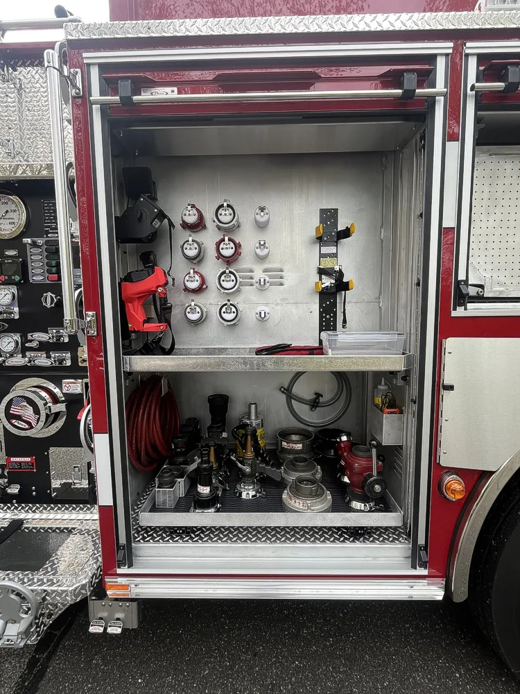 Open side compartment with hose fittings, adapters, and appliance storage beside the pump panel