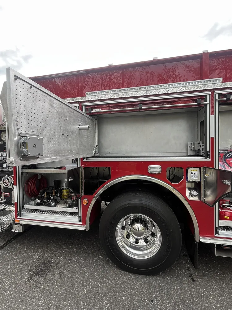 Open upper side compartment over rear wheel with side door raised and wheel area visible