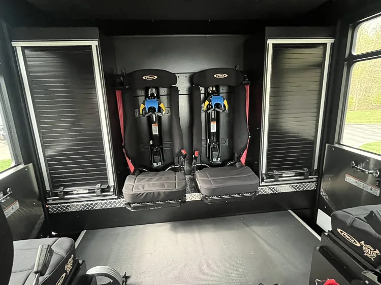 Rear crew compartment interior view with fold-down seats and SCBA seat mounts