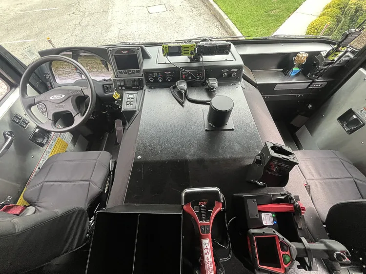Cab interior view showing command console, seats, radios, and dashboard controls