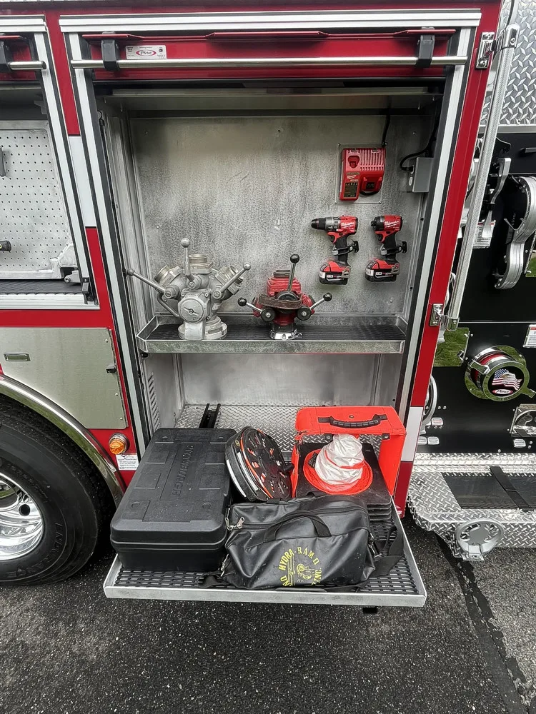 Open upper side compartment above rear wheel showing mounted hand tools and rear tire