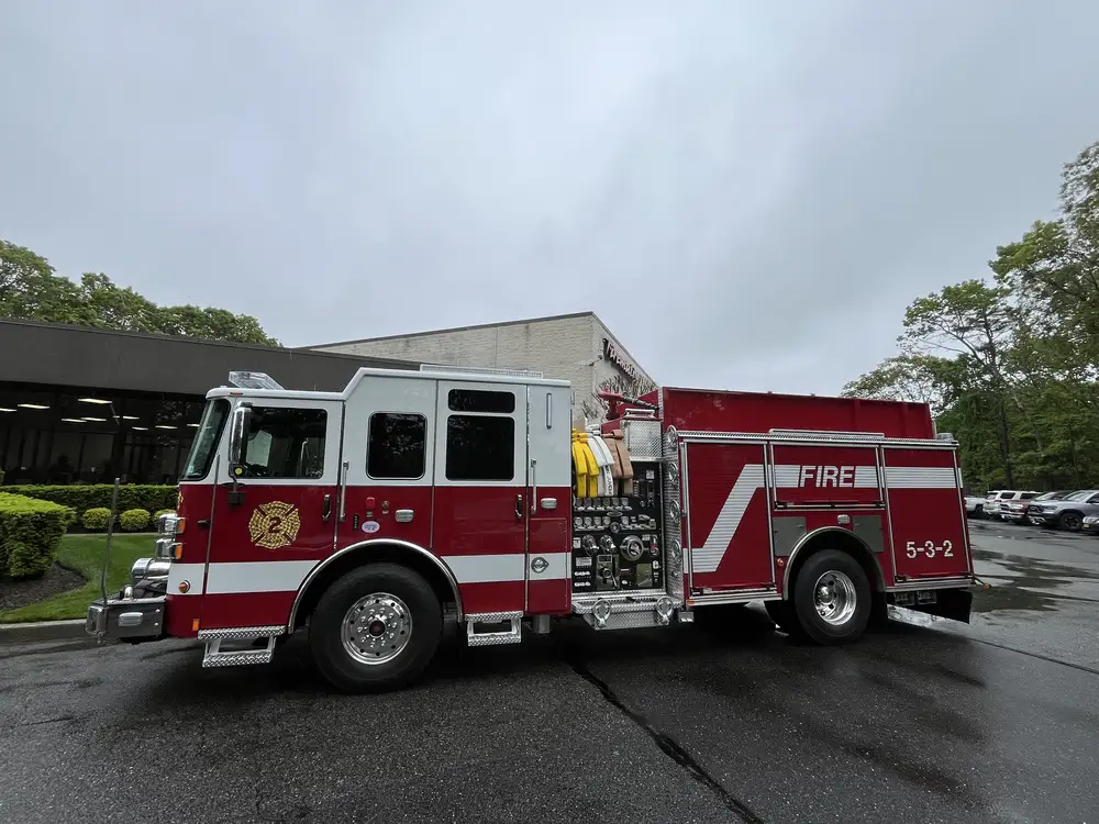 Pumper officer-side profile view showing pump panel, side compartments, and rear wheel