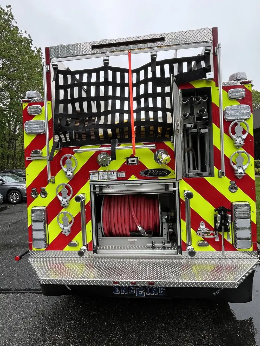 Rear view with open rear-side compartment showing mounted tube holders and rear hose reel