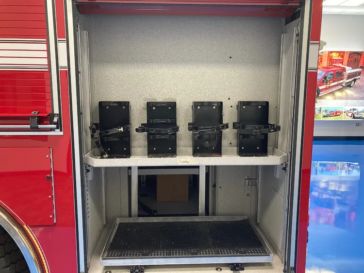 Open side compartment showing stacked black equipment bins