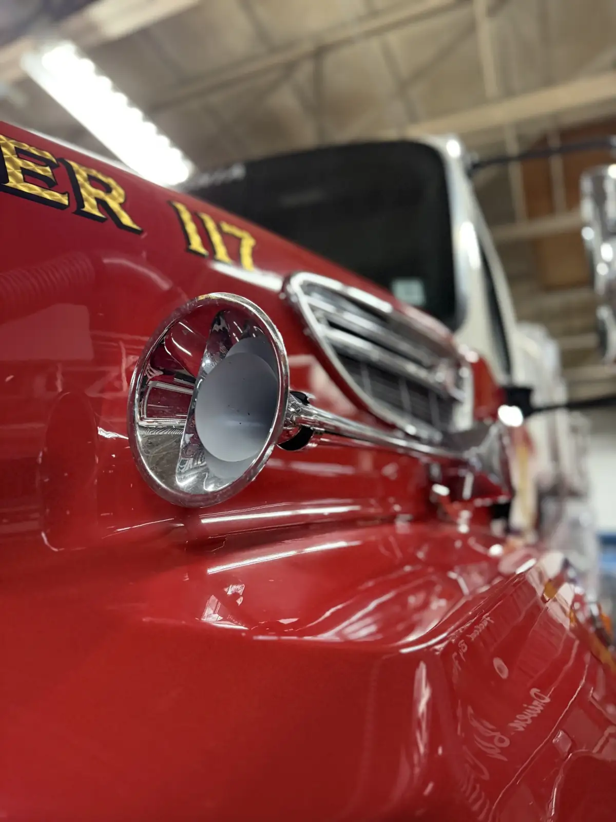 Close-up of hood-mounted chrome siren and front hood lettering