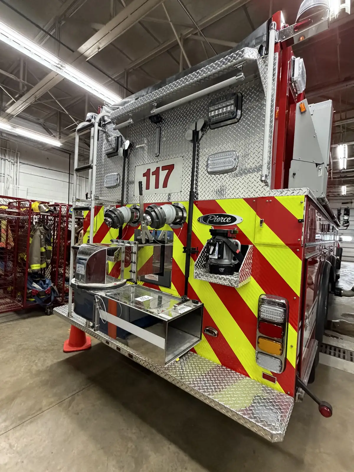 Rear-right view showing chevron striping, rear discharges, and dump chute