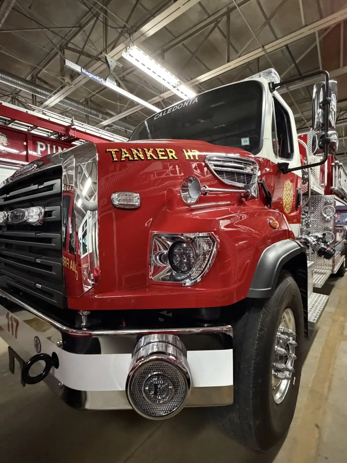 Front-right close-up showing bumper-mounted siren, headlight, and hood lettering