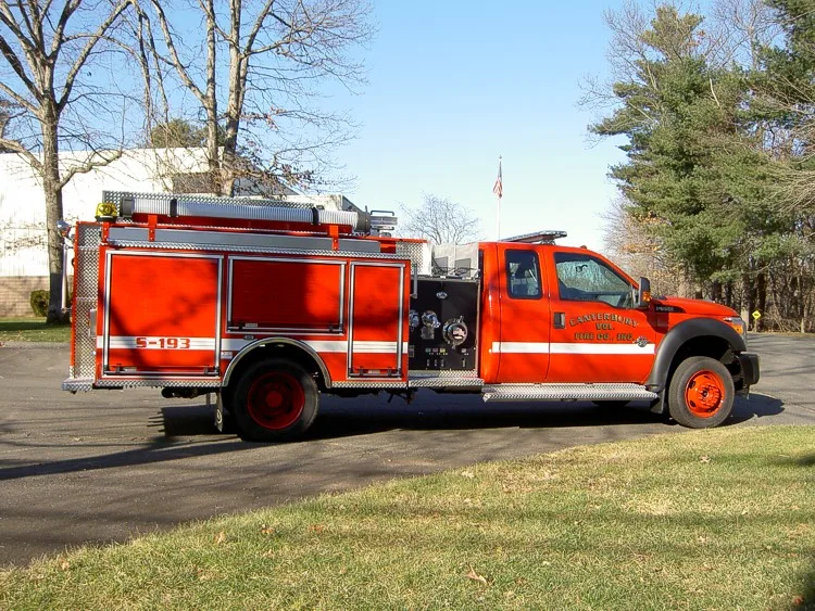 Driver-side full profile showing pump panel area, side compartments, and wheel layout