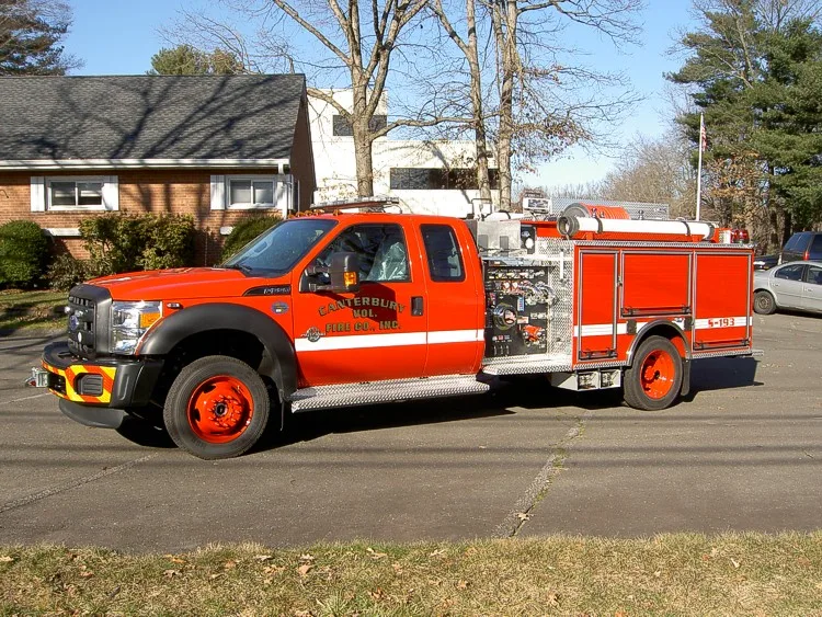 Passenger-side full profile showing pump controls behind cab and compartment body