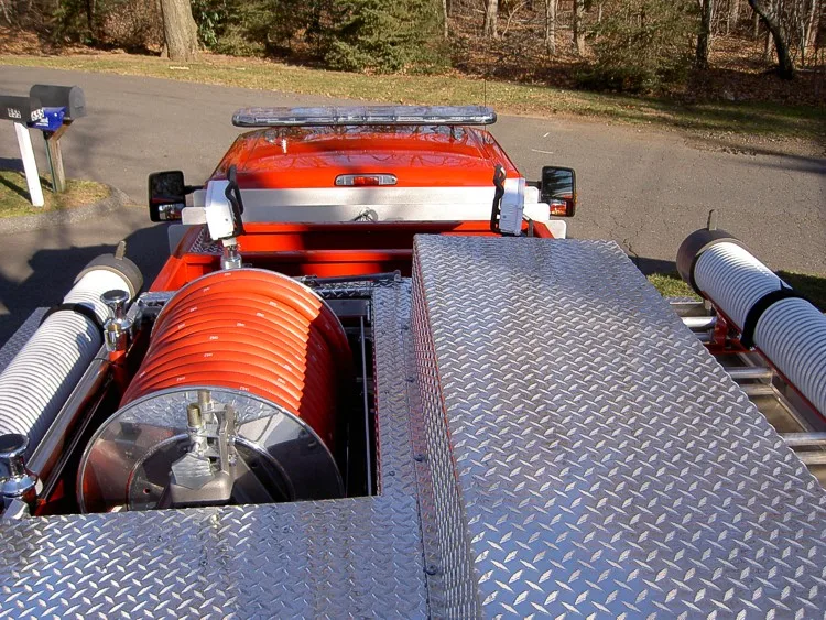 Overhead hosebed view showing orange hose reel and diamond-plate deck
