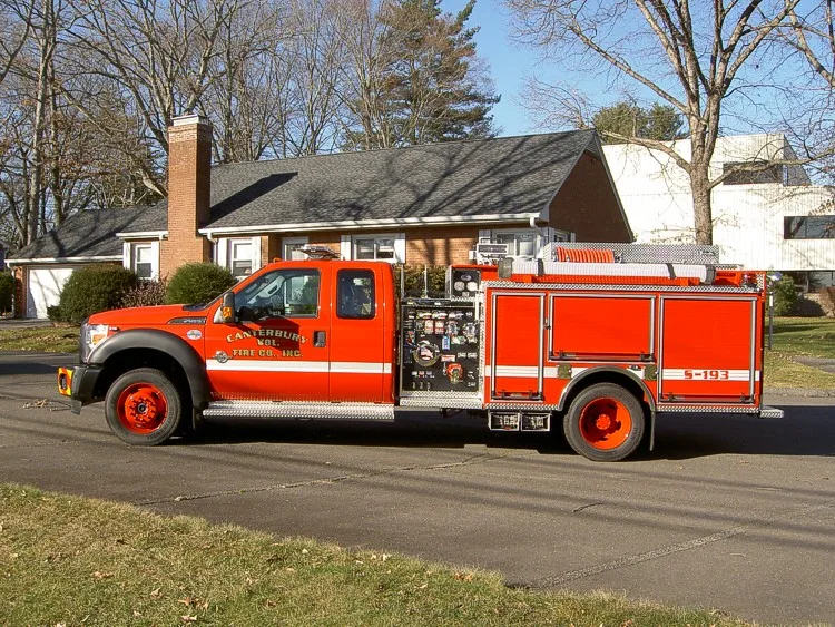 Driver-side profile view showing pickup cab, pump panel, and rear compartments