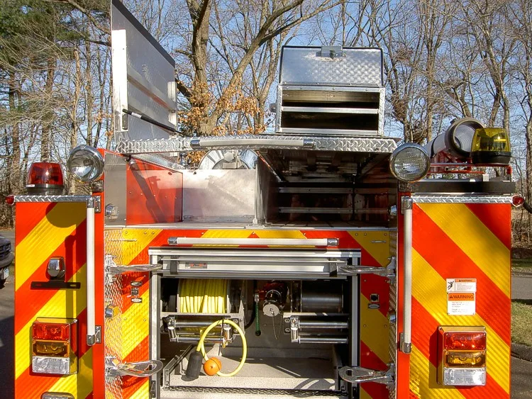 Rear upper compartment view with open doors showing hose reel and rear equipment bay