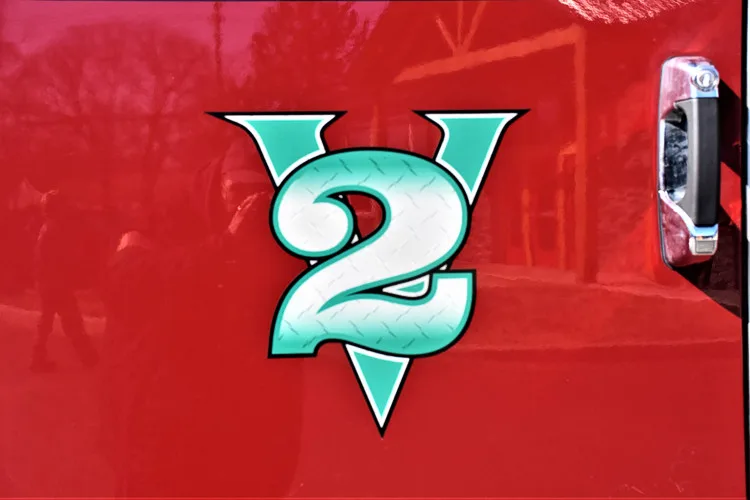 Body emblem close-up showing a green number decal on red panel