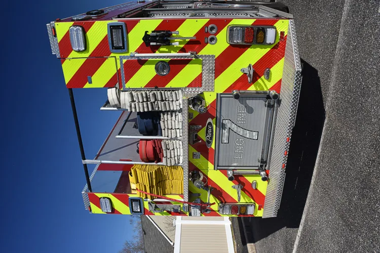 Rear view showing red-and-yellow chevrons, rear lights, and open center compartment