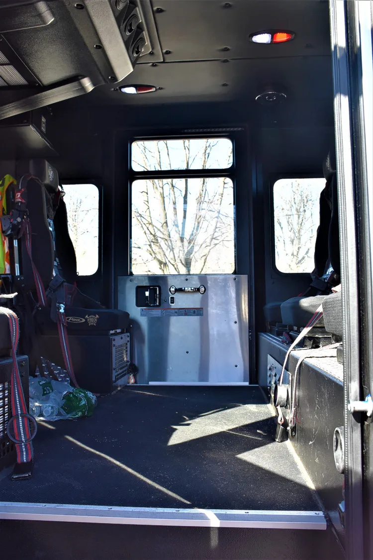 Rear crew cab interior view showing seating, aisle space, and interior paneling