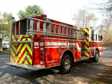 Rear-right exterior view showing chevron rear panel, hosebed, and side hose rails