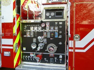Pump panel close-up showing gauges, levers, valves, and discharge controls