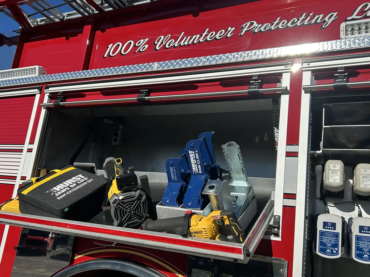 Slide-out tray close-up with battery rescue tool and saw handle