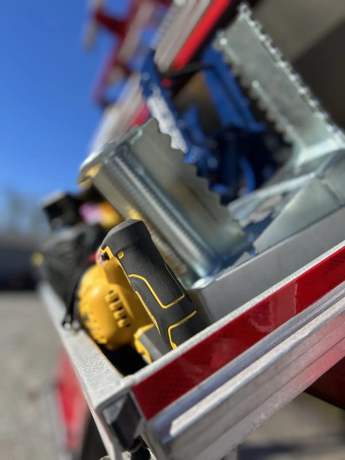 Rear side compartment open showing yellow gear bags and mounted hand tools