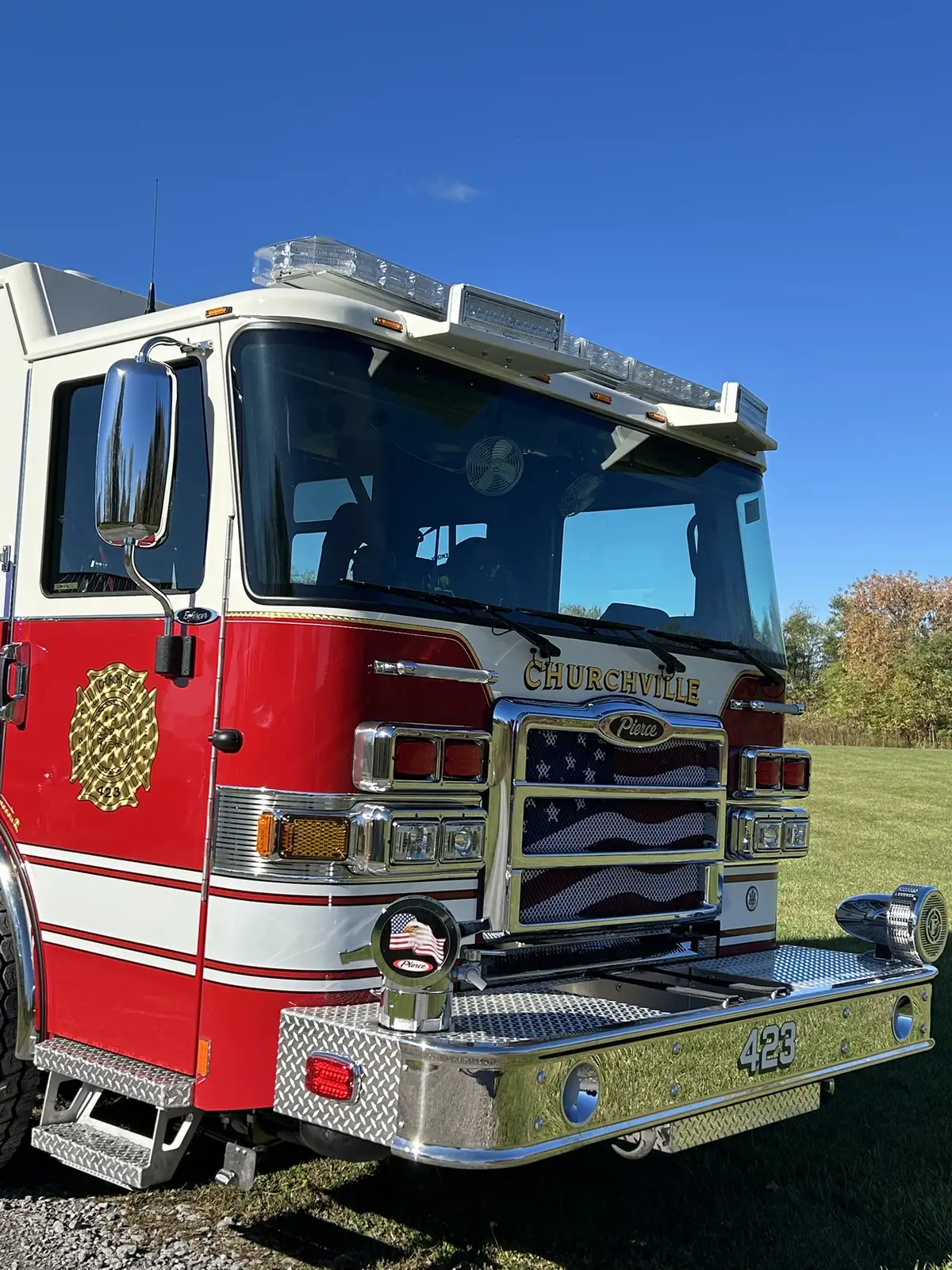 Pierce pumper front-right view with sunlight flare and full side body