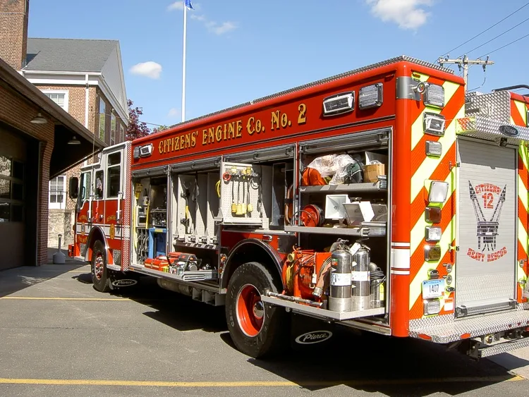 Rear-left exterior view with compartments open showing tools and gear