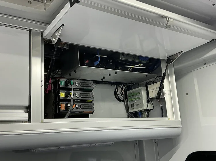 Overhead cabinet compartment open above command workstation