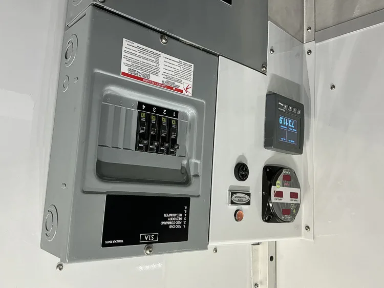 Electrical control panel close-up with breaker switches and shore power gauge