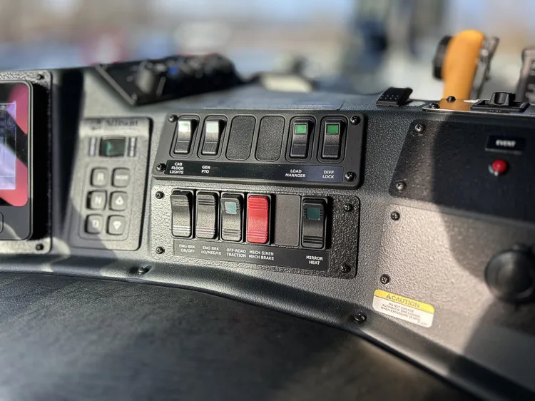 Dashboard control panel close-up with rocker switches and warning button
