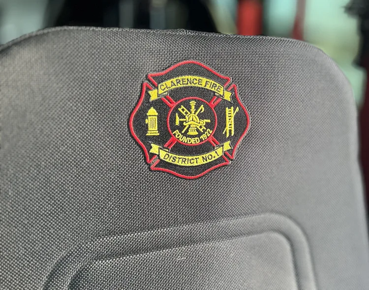 Circular fire service badge close-up on red panel