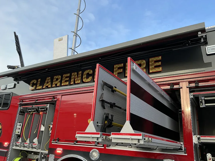 Driver-side rear view with open compartments and ladder storage area