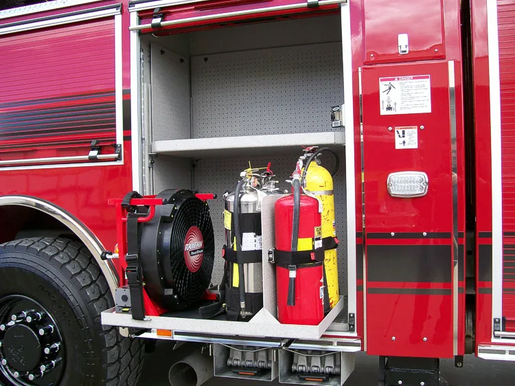 Open side compartment showing mounted extinguishers and hose reel storage