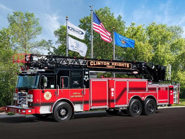 Tower ladder truck side profile view with American flag flying above ladder