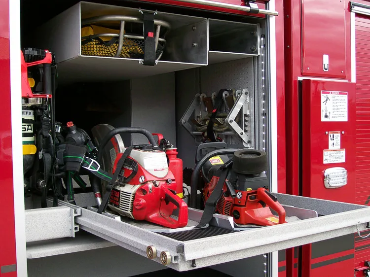 Open side compartment showing rescue saws and equipment on pull-out tray