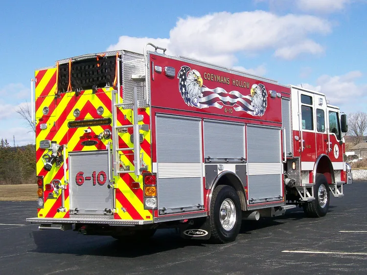 Rear-right exterior view showing red-yellow chevrons, rear intake and discharge fittings, and side compartments.
