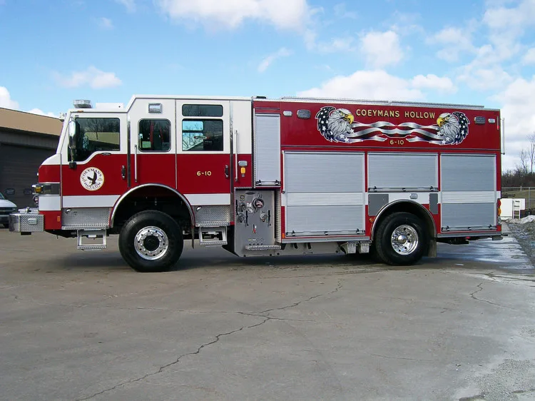 Driver-side full profile showing the pump panel section, side compartments, and full wheelbase.