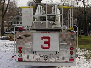 Rear view showing aerial ladder base, rear body panel, and warning lights