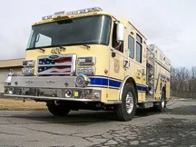Rescue pumper front-left exterior view showing enclosed cab and side compartments