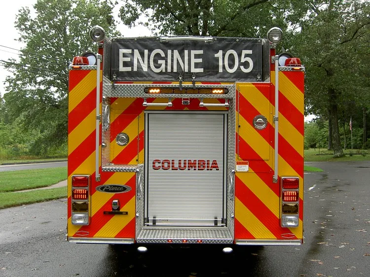 Rear view showing chevron striping, rear roll-up door, and warning lights