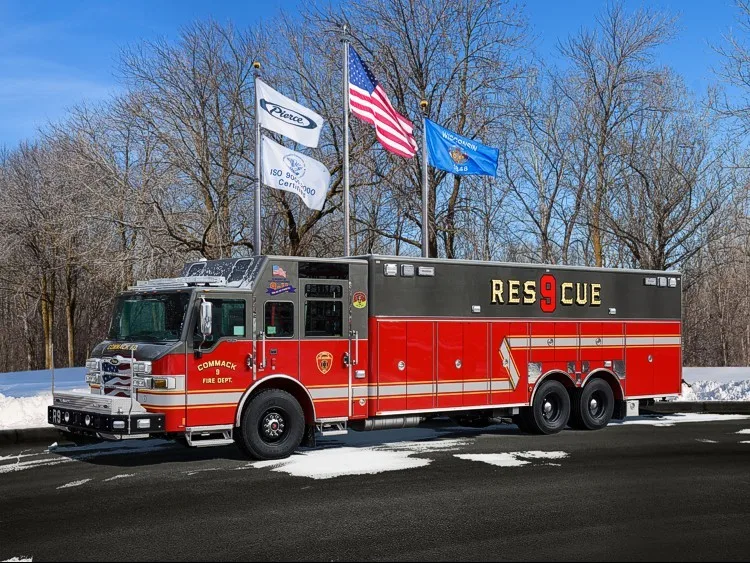 Heavy rescue truck front-left exterior view parked near flags