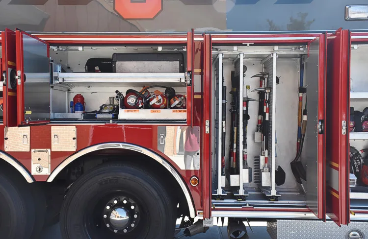 Open side compartment showing shelves with nozzles, tools, and equipment bags