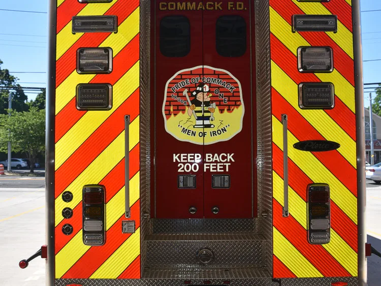 Rear view showing red-and-yellow chevrons and center rear compartment door