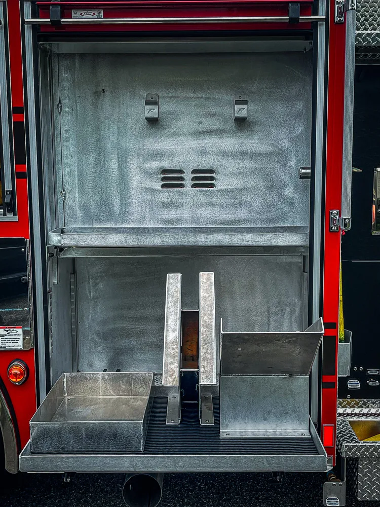 Open rear body compartment showing empty slide-out tray and mounting rails