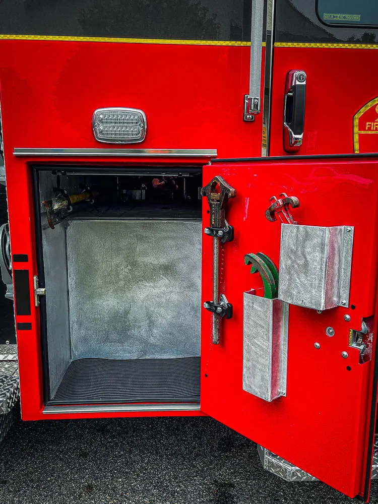 Open body compartment close-up showing panel edge and adjacent storage bay