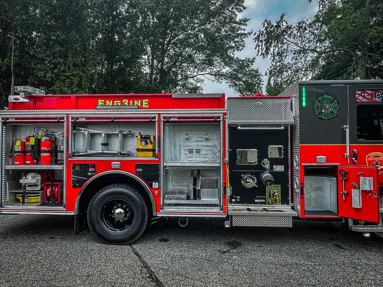 Driver-side profile with open compartments showing tools and equipment layout