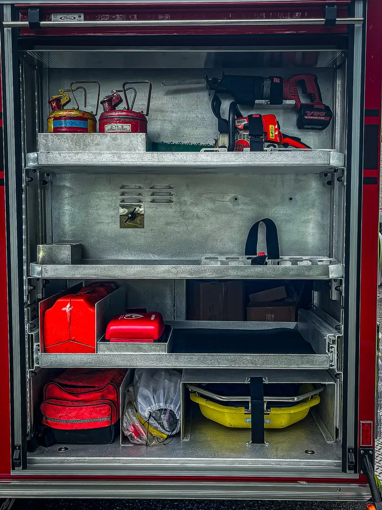 Open side compartment showing shelves with helmets and equipment bags