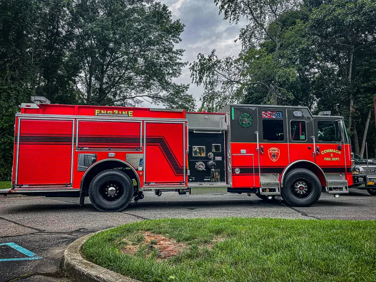 Driver-side profile view showing pumper body, rear wheel, and side compartments