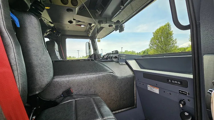 Cab interior side view showing front seat, dashboard, and windshield