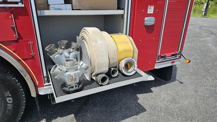 Lower side compartment close-up showing hose reel and intake fittings