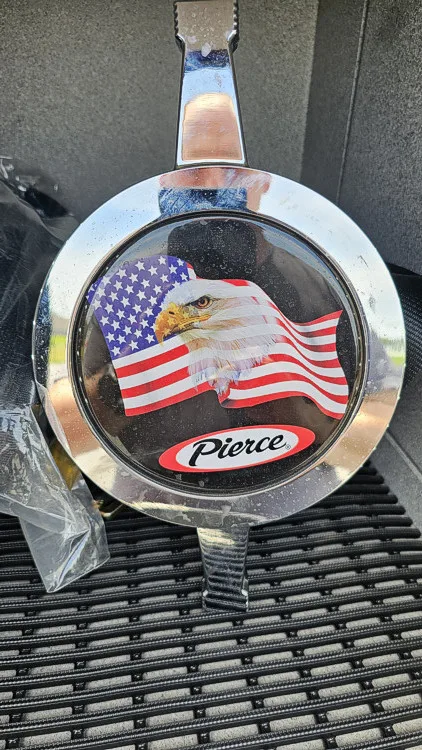 Front grille badge close-up showing circular emblem on chrome bars