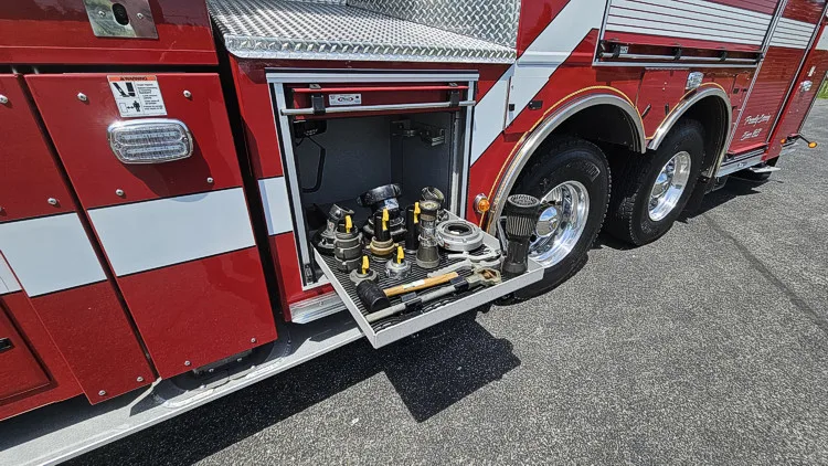 Open lower side compartment showing tools and equipment organized on trays